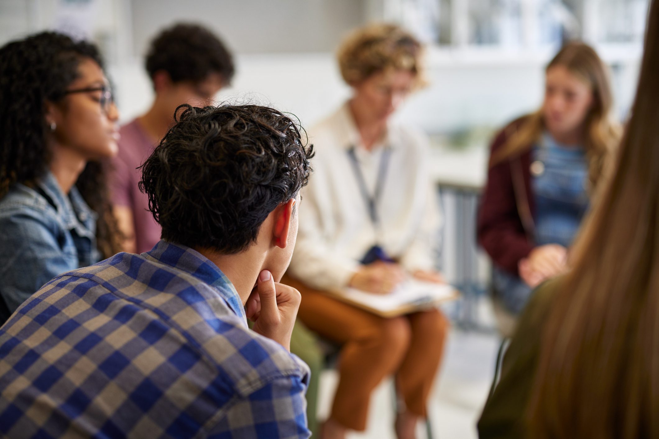 Four adults in a therapy session.